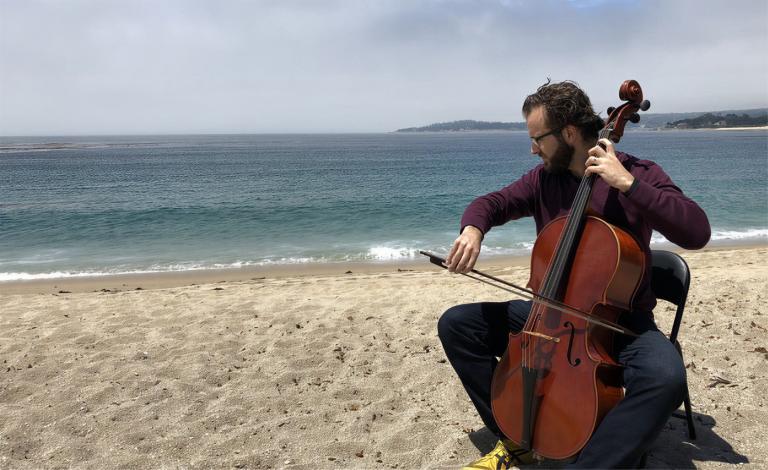 Paul is playing cello by the beach