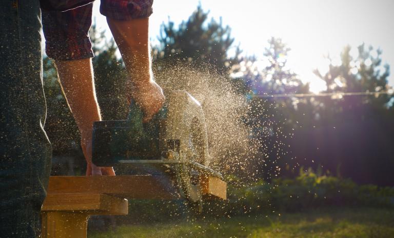 Man standing with chainsaw in a garden