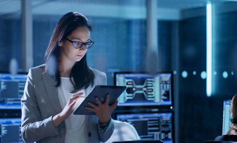 Technical industrial engineer overseeing robotics with system software monitoring and Icon Industry network connectivity on tablet.