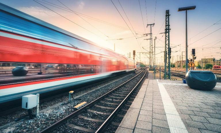 A high-speed train is passing by a train station.