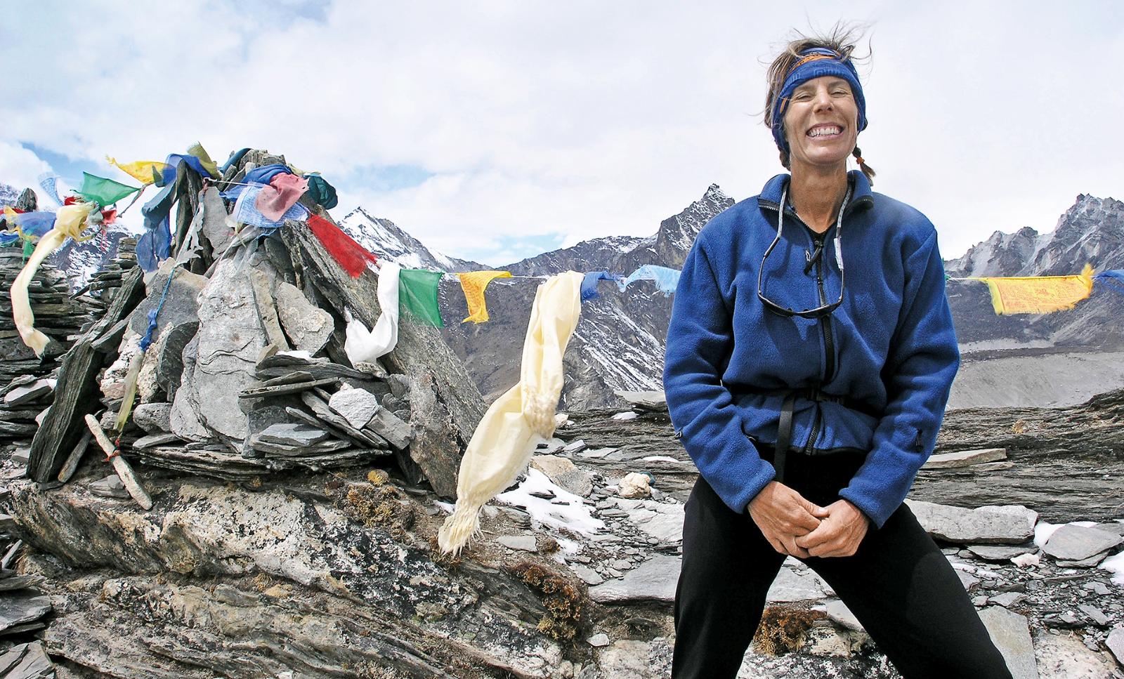 A close-up of base camp at Mount Everest, two orange tents erected in front of a mountain backdrop.