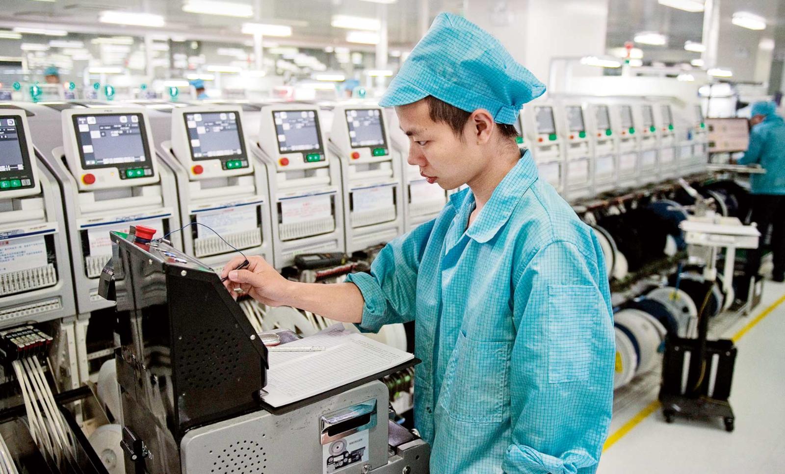 Innovative Production: A worker operates a machine at the Oppo factory in Dongguan.