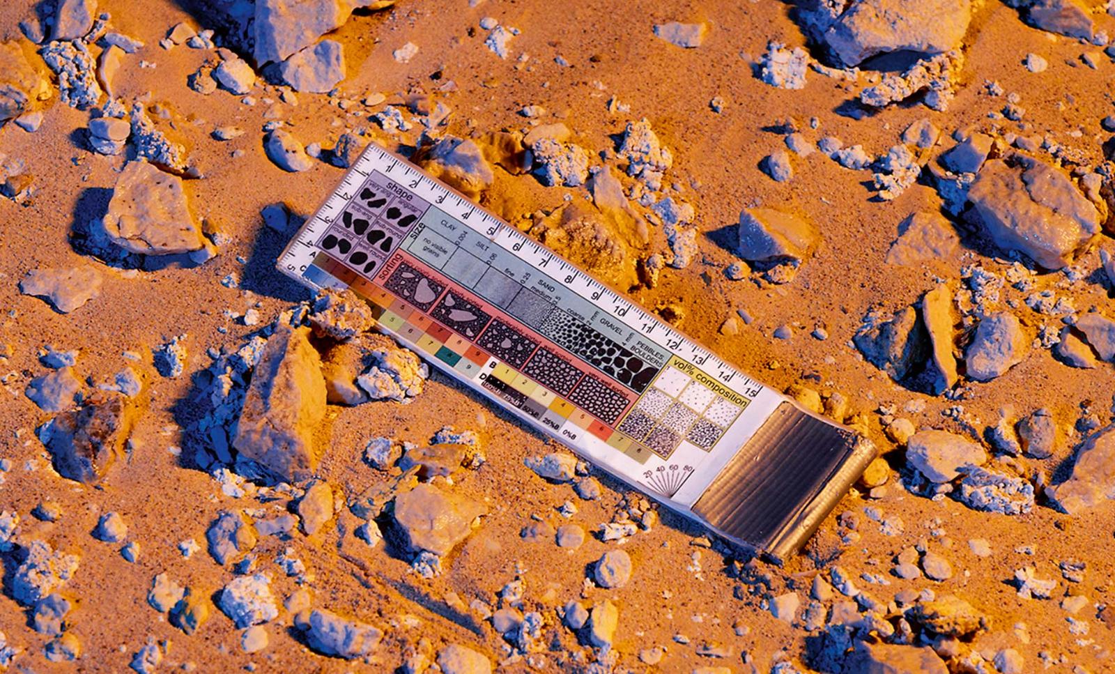 Two analog astronauts conduct a field spectrometry experiment in the desert