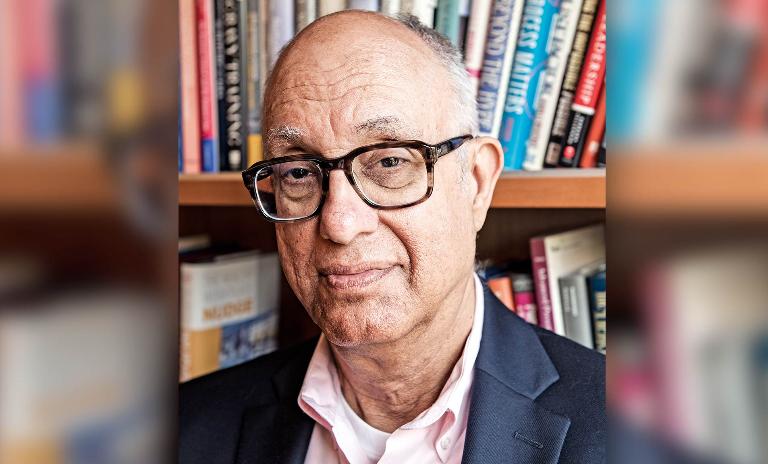 A portrait of business theorist Jeffrey Pfeffer in front of a bookshelf