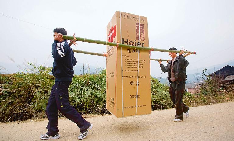 A global innovator: Chinese farmers carry a Haier refrigerator on their way back to their village in Anhui.