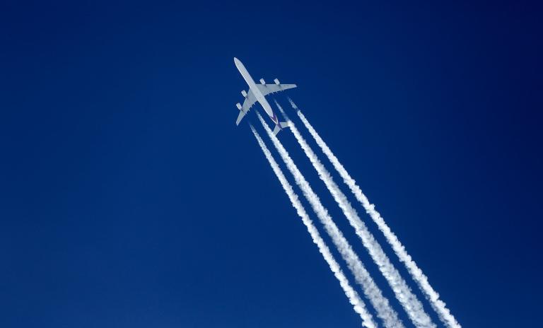 A jet airliner with contrails.