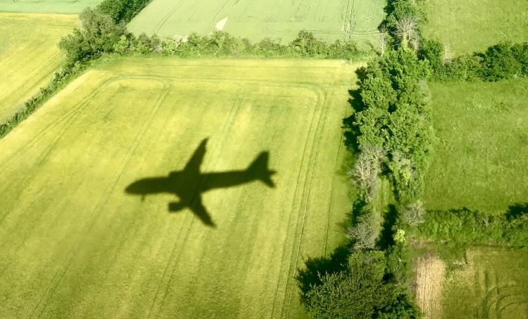 shadow of an airplane on a green field.