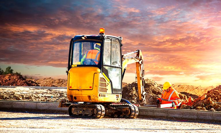 Small electric excavator and construction workers