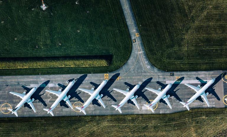 Photo of planes standing in a row in the parking lot.