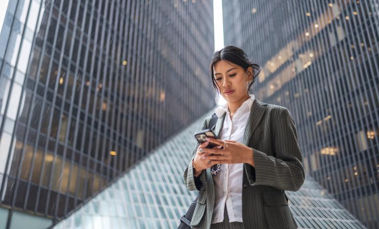 An Asian businesswoman using mobile phone in the city.