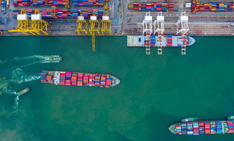 Container ships maneuvering through a port.