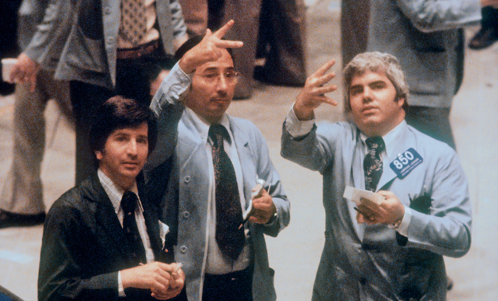 Drei Broker an der New Yorker Börse. Zwei von ihnen formen Zahlen mit ihren Fingern. (c) Burt Glinn/Magnum Photos/Agentur Focus