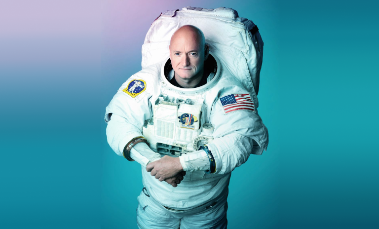 The astronaut Scott Kelly in his spacesuit, holding his hands together. (c) Robert Markowitz