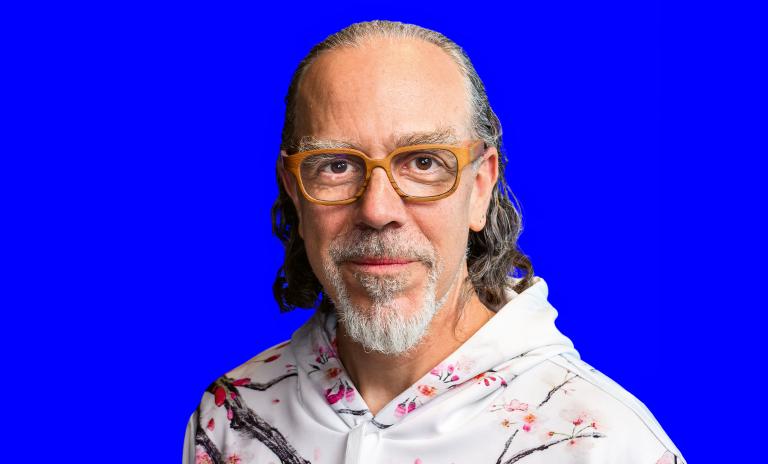 Portrait of Astro Teller wearing a white hoodie and looking directly into the camera.