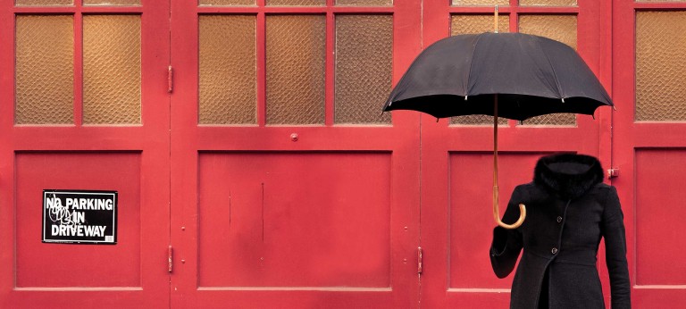 An umbrella, woman’s coat and high heel shoes float in the air without a body