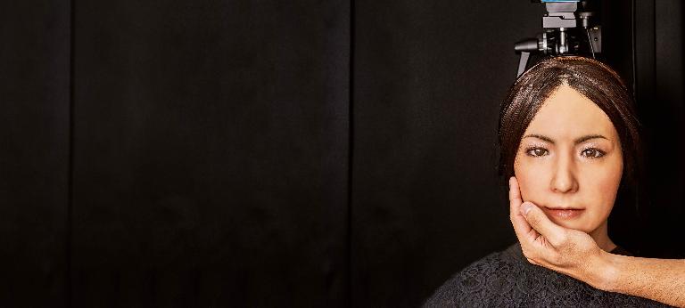 A human hand touches the face of Erica, the world’s first autonomous robot